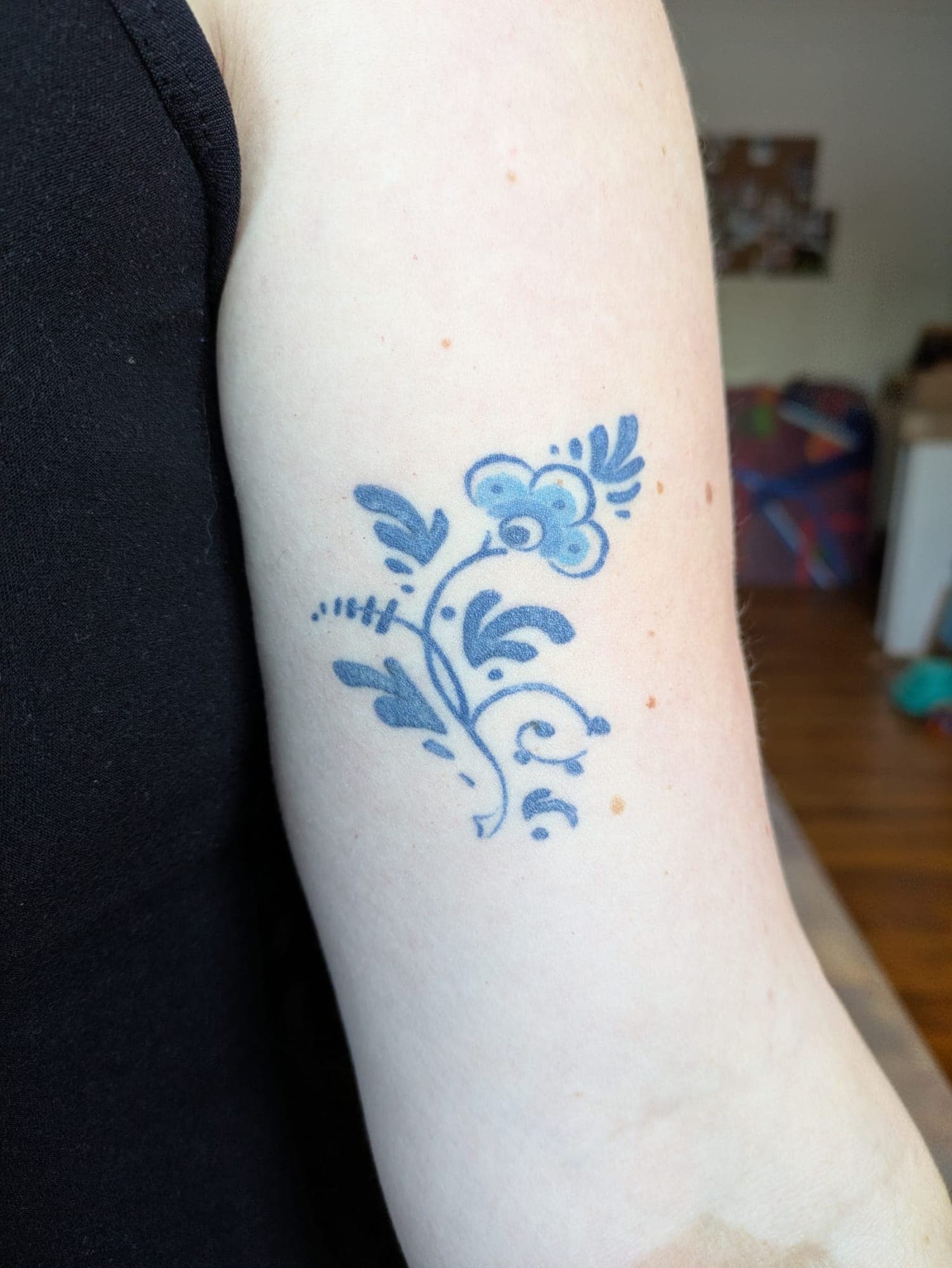 Healed Delft Blue tattoo, delft floral upper arm