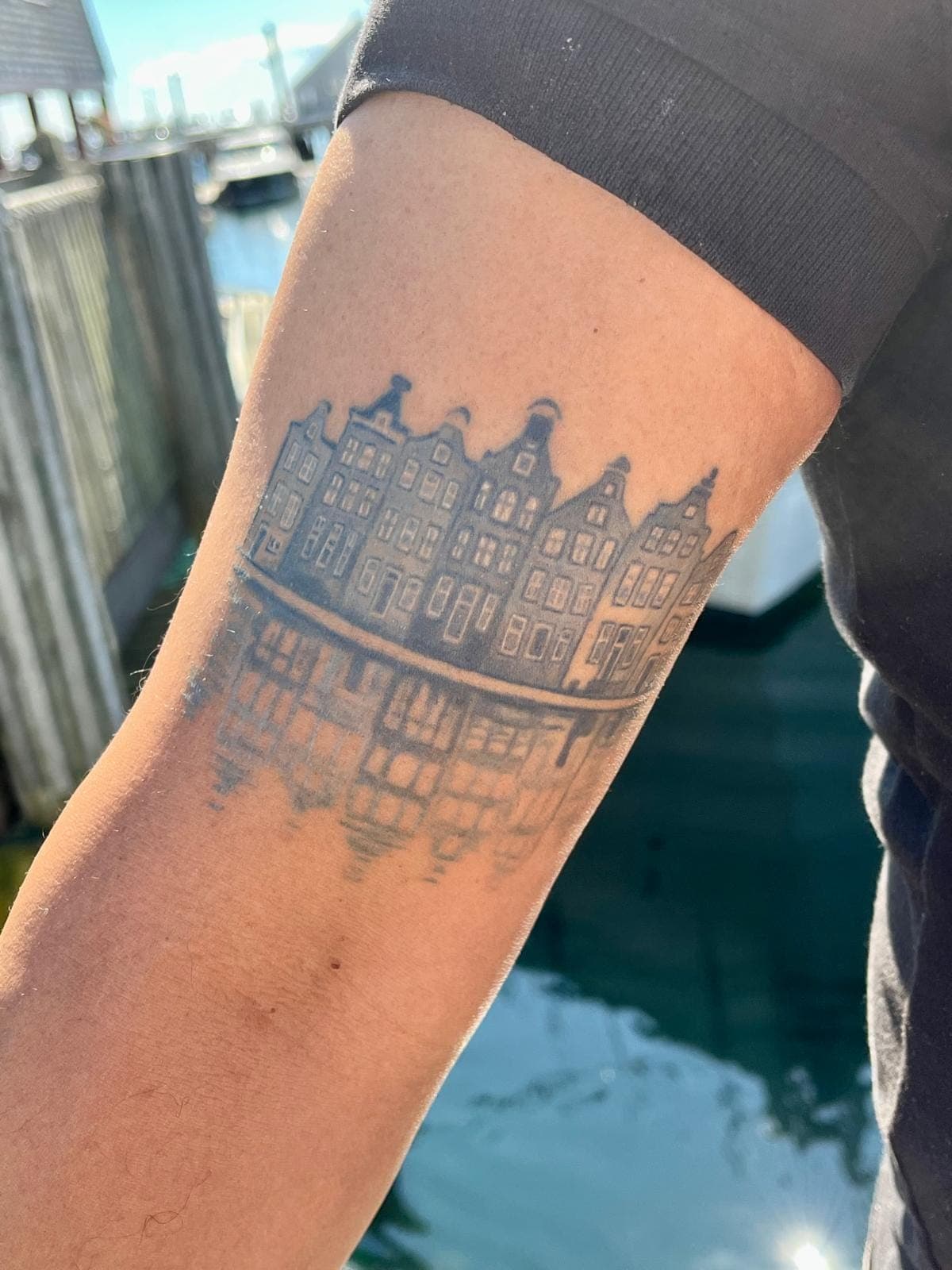 Healed Delft Blue tattoo, dutch canal houses arm